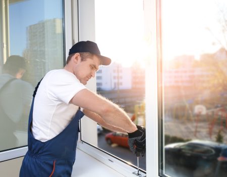 Construction worker repairing window in house